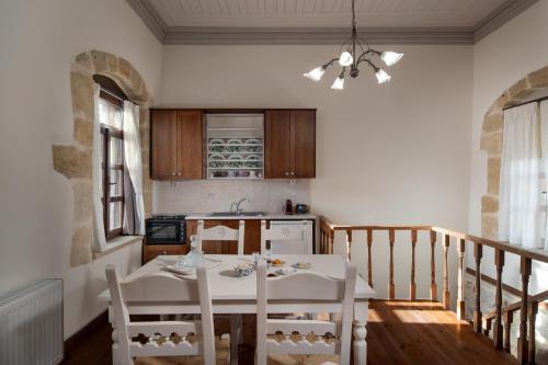 a kitchen with a table and chairs in a room at Arhontiko Arhanes Suites in Archanes