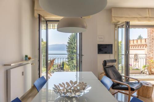a dining room with a table and chairs and a balcony at Blue Dream in Ispra