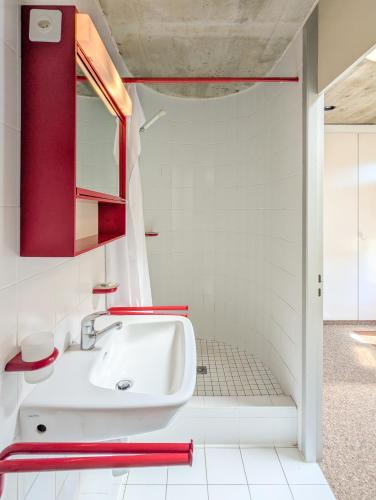 a bathroom with a white sink and red cabinets at Charmant appt Chailly sur Montreux avec terrasse in Montreux