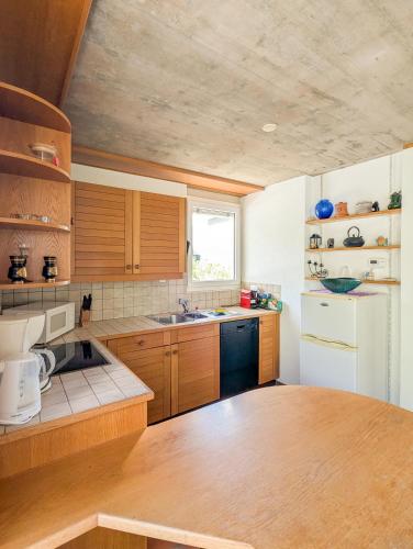 a kitchen with wooden cabinets and a white refrigerator at Charmant appt Chailly sur Montreux avec terrasse in Montreux