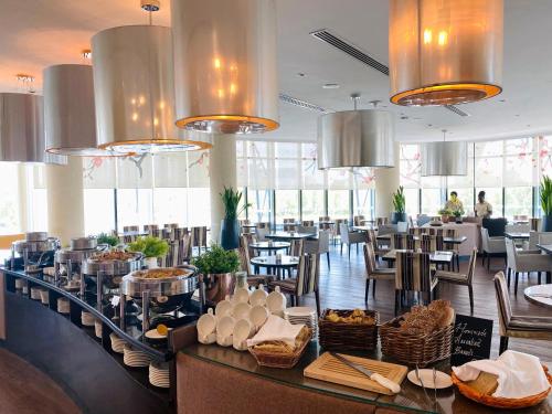 a restaurant with tables and chairs and chandeliers at Holiday Inn Abu Dhabi by IHG in Abu Dhabi