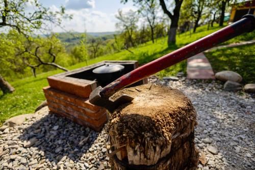 a fire pit with a stick on top of a tree stump at Cabana Galaxy A Frame by Cabanele Galaxy in Cucuteni