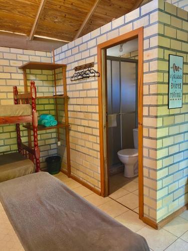 a small room with a bathroom with a toilet at Haleakala Hostel & Pousada in Praia do Rosa