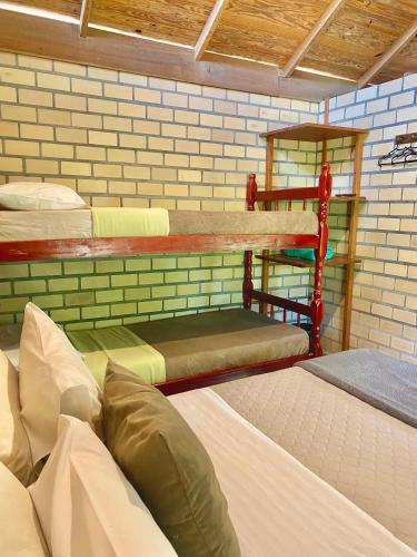 a room with three bunk beds in it at Haleakala Hostel & Pousada in Praia do Rosa