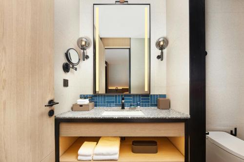 a bathroom with a sink and a mirror at Four Points by Sheraton Kunming Dongfeng Square in Kunming
