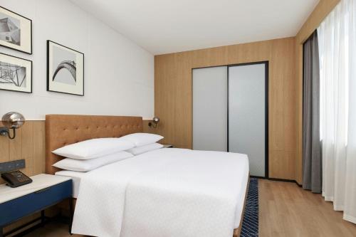 a bedroom with a white bed and a window at Four Points by Sheraton Kunming Dongfeng Square in Kunming