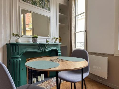 une pièce avec une table, des chaises et une cheminée dans l'établissement Le Foyer Chartrain, à Chartres