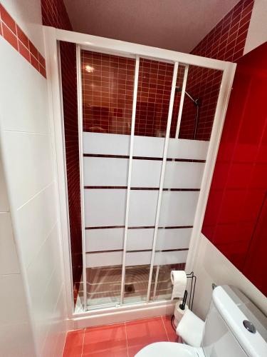 a red and white bathroom with a toilet and a window at Apartamento Pigem a paso de la playa en Salou in Salou