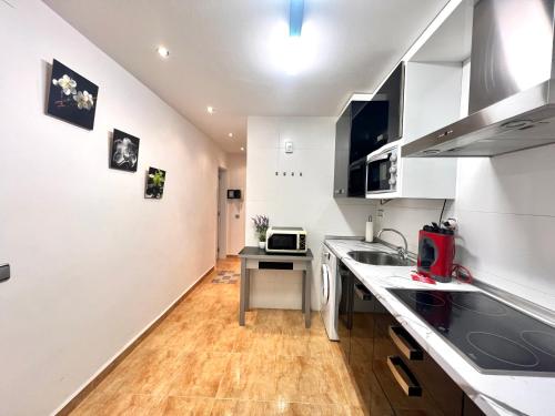 a kitchen with white cabinets and a counter top at Apartamento Pigem a paso de la playa en Salou in Salou