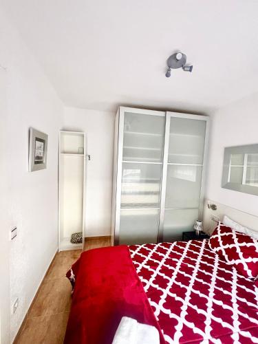 a bedroom with a red blanket on a bed at Apartamento Pigem a paso de la playa en Salou in Salou