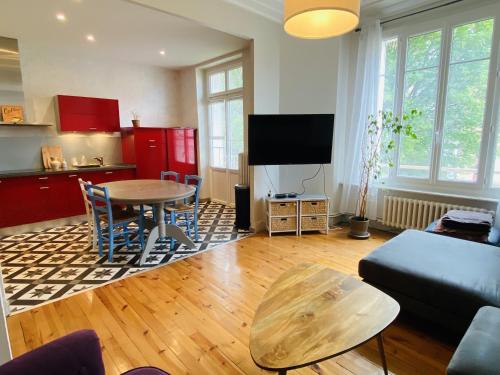 un salon avec une table et une cuisine dans l'établissement l'ART DECO, à Rodez