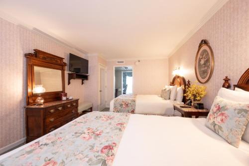 a hotel room with two beds and a mirror at Boardwalk Plaza Hotel in Rehoboth Beach