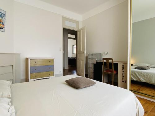 une chambre avec un grand lit blanc et un miroir dans l'établissement l'ART DECO, à Rodez