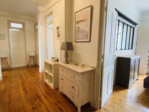 une chambre avec une commode et une lampe sur une commode dans l'établissement l'ART DECO, à Rodez