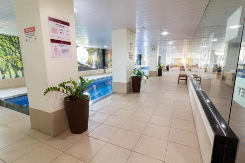 a hospital hallway with benches and potted plants at Arrey Gran Hotel in Teresina