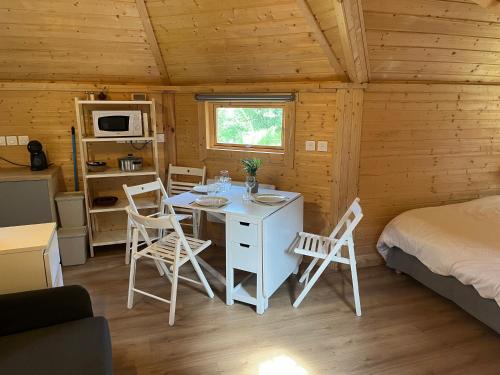 une chambre avec une table et des chaises dans une cabine dans l'établissement Les chaumines, à Albé