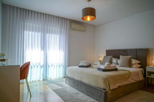 ein Schlafzimmer mit einem Bett und einem großen Fenster in der Unterkunft GuestReady - Salomão Luminous Apartment in Senhora da Piedade