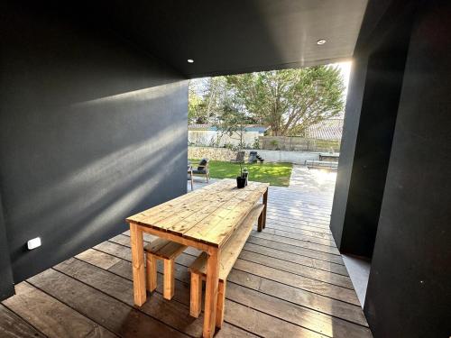 une table en bois assise sur une terrasse en bois dans l'établissement Maison bord de mer Anglet, à Anglet
