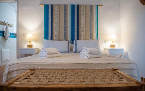 a bedroom with a large bed with towels on it at Giallo Limone in Teulada