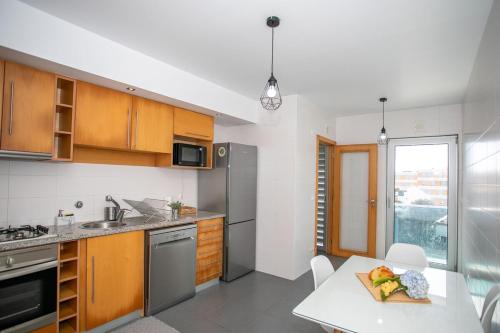 eine Küche mit Holzschränken und einem Tisch mit einem Teller Essen in der Unterkunft GuestReady - Salomão Luminous Apartment in Senhora da Piedade