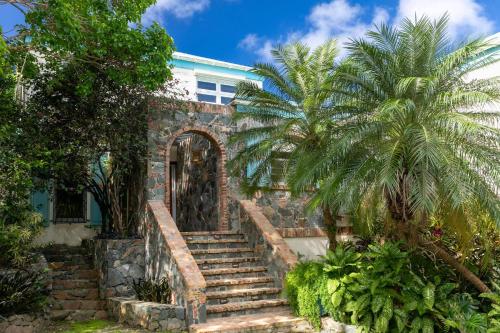 a house with stairs and a palm tree at Cielo Vista Villa 3 BDRM Sleeps 6 Heavenly View in Cruz Bay