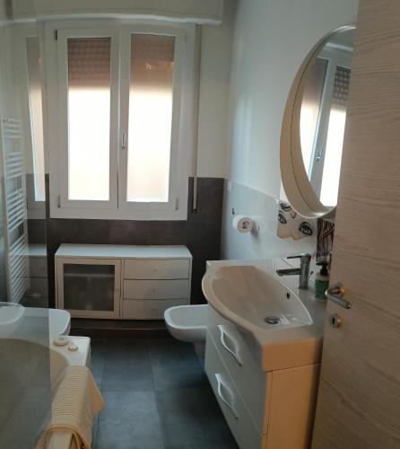 a bathroom with a sink and a toilet and a mirror at Armonia Affittacamere in San Vicenzo di Galliera