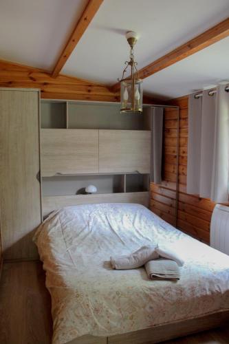 une chambre avec un lit avec un plafond en bois dans l'établissement Le Chalet, à Montfroc