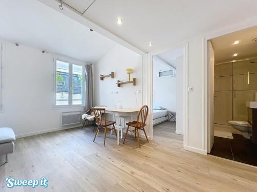 une chambre avec une table et des chaises et une salle de bains. dans l'établissement Calm & Cozy Flat Flowered Alley Sleeps 4, à Paris