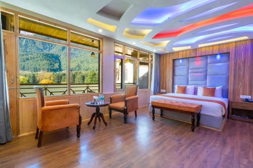 a bedroom with a bed and a table and chairs at Hill Rive Resort in Manāli