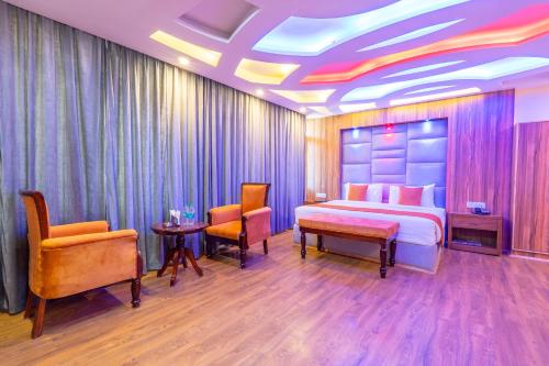 a hotel room with a bed and two chairs at Hill Rive Resort in Manāli