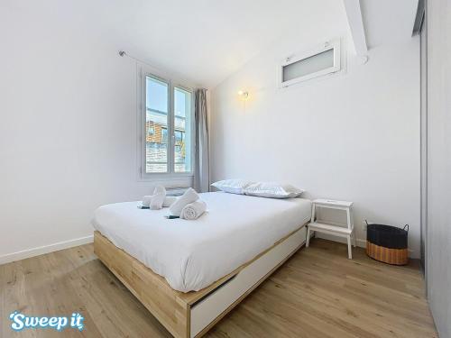 une chambre avec un lit avec des draps blancs et une fenêtre dans l'établissement Calm & Cozy Flat Flowered Alley Sleeps 4, à Paris