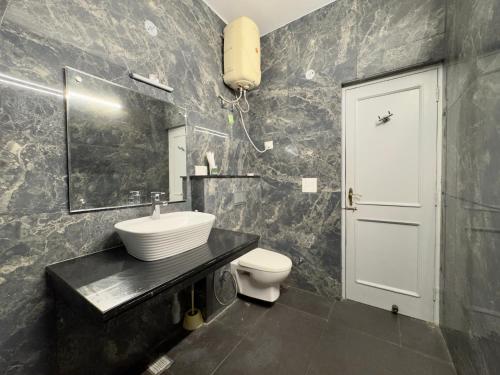 a bathroom with a sink and a toilet at Atreya Boutique Cottage Serene Villa Near Ram Jhula in Rishīkesh