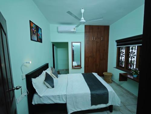 a bedroom with a bed and a ceiling fan at Angel Homestay Paravoor in Alleppey