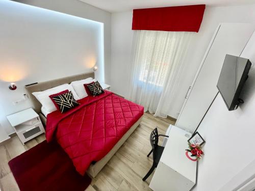 a bedroom with a red bed with a red blanket at ARBI VENICE STATiON in Mestre