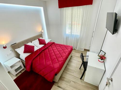 a small bedroom with a red bed and a desk at ARBI VENICE STATiON in Mestre