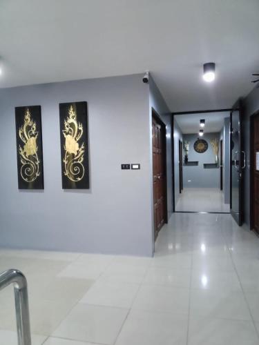 a hallway with two paintings on the wall at Sparta Patong in Ban Nong Chaeng