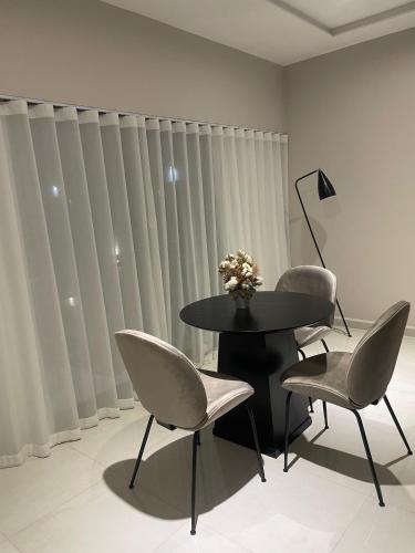 a table and chairs in a room with vertical blinds at Hotel Boutique Gualamba in General Pinedo