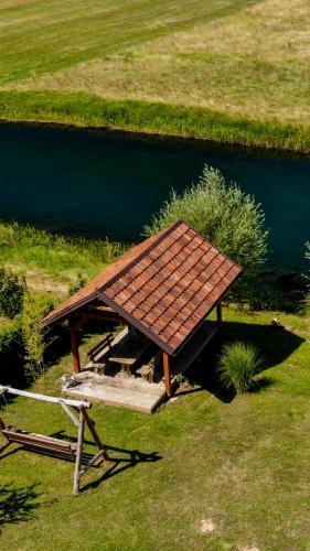 a picnic table sitting next to a body of water at House Arupium - HOT TUB in Otočac