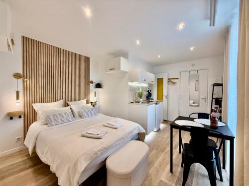 une chambre avec un grand lit blanc et une table dans l'établissement Studio 2 - Cinéma Sport Parking - DABNB, à Limoges