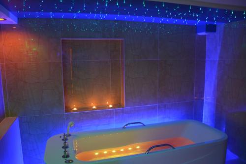 a bathroom with a tub with a mirror and lights at Willa Panorama Medical Spa in Ustroń