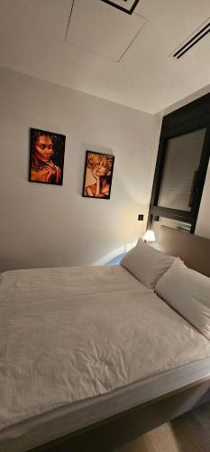 a bedroom with three pictures hanging on the wall at Stan 7 in Loznica