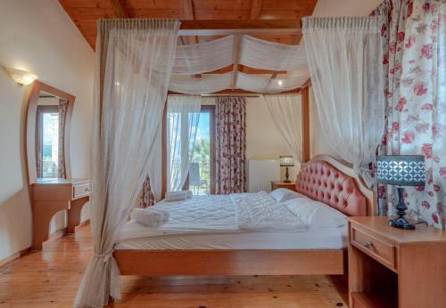 a bedroom with a canopy bed with a window at Teacher Cottage in Agia Triada