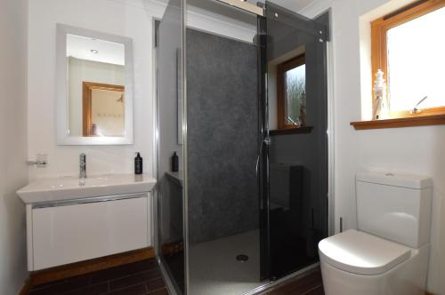 a bathroom with a shower and a toilet and a sink at Kennacraig Lodge in Whitehouse