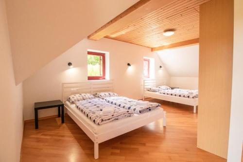 two beds in a room with two windows at Bohinj Cozy Escape Holiday Home in Bohinj