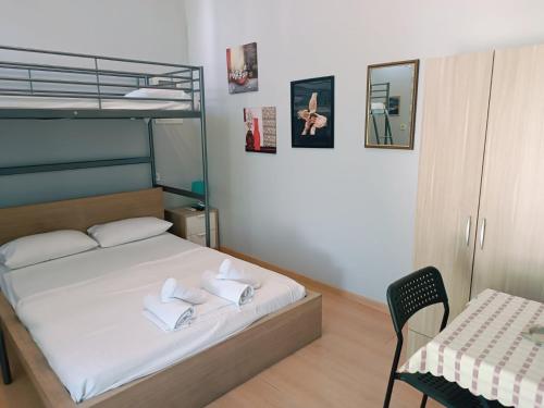 a bedroom with a bunk bed with a table and a chair at Apartments Konstantinidis in Nea Potidaea