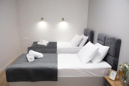 two beds in a hotel room with towels on them at Wisteria Hotel in Laskowiec