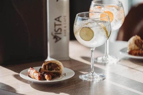 a table with a glass of wine and a plate of food at The View Hotel in Eastbourne