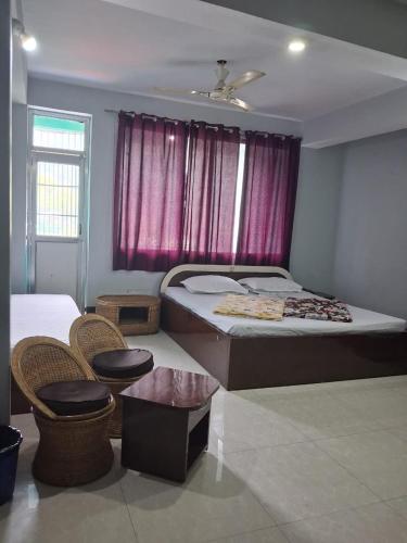 a bedroom with a bed and two chairs and a window at Hotel mountain rangpo in Jāmb