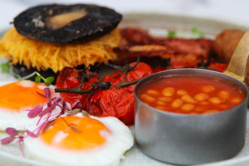 a plate of food with eggs and beans and a sandwich at Coach & Horses Dersingham in Dersingham