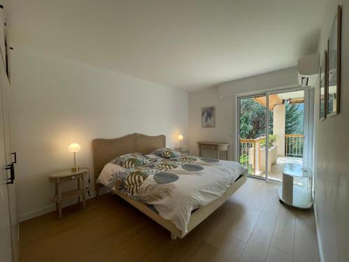 une chambre avec un lit et une porte coulissante en verre dans l'établissement MANDELIEU 2 BEDROOMS APARTMENT with Swimming Pool, à Mandelieu-la-Napoule